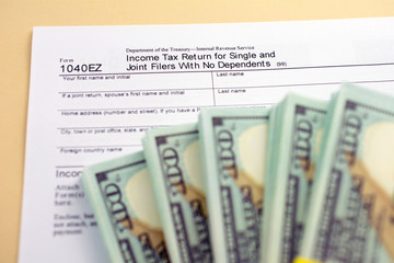  tax form 1040 with money on table. Lodging your tax return
