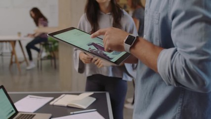 young diverse business people brainstorming graphic design team using tablet computer designing website layout sharing ideas working together on creative project in trendy office