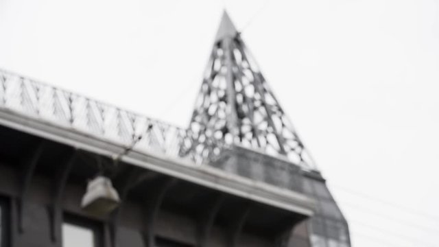 Architecture metal tower structure on city house and shaking street light along gray cloudy sky, blur in