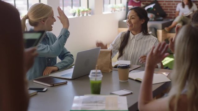 happy diverse business women meeting colleagues high five celebrating success enjoying successful project presentation in modern office workplace