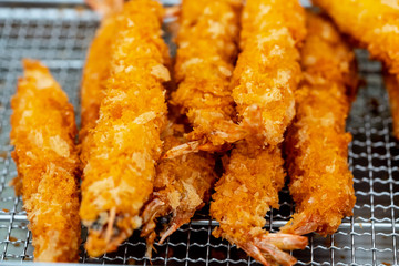 The crisp and tender taste of fried shrimps are stacked on deep fryer to reduce oil and temperature for easy eating.