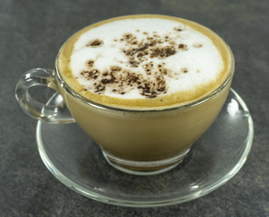 Cappuccino Hot coffee in glass cup on stone floor background,Close up..