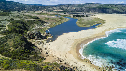 Fototapeta na wymiar An aerial drone view over Tunquen Beach in Valparaiso region and close to Algarrobo, an awesome beach with a lot of wildlife because of it wetlands and turquoise waters, an idyllic travel destination