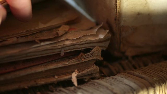 Hand searching through old dusty stored manuscripts