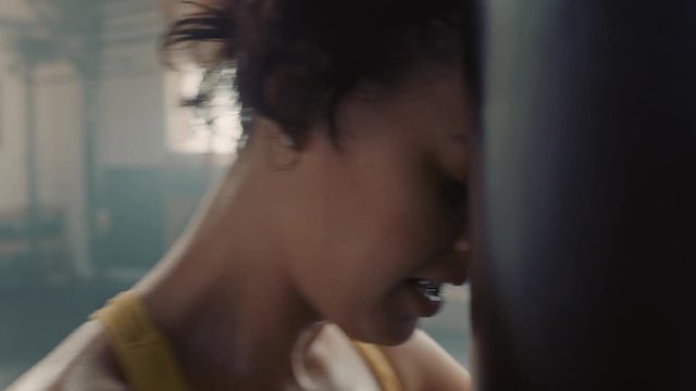 healthy woman athlete training kickboxing exercise workout punching bag strong female fighter exhausted resting after practice in fitness gym wearing boxing gloves