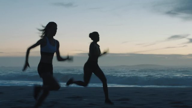 silhouette woman athlete running overtaking in race competition female runners training intense cardio workout on beach at evening sunset close up