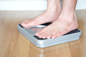 Legs of men standing on scales weight. Concept of health and weight loss.