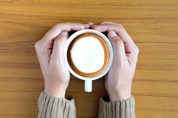 Hand of woman holding coffee cup and open read book and the smartphone is on the table. Educational and relax holiday Ideas