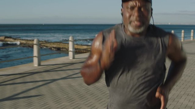 overweight mature african american man running intense training weight loss workout black male runner jogging on calm early seaside morning at sunrise