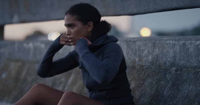 attractive young woman runner resting exhausted after intense running exercise in city at sunset training cardio workout enjoying urban fitness lifestyle