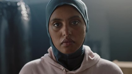 portrait muslim woman athlete looking confident at camera tough female kickboxer sportswoman wearing hijab headscarf in fitness gym close up