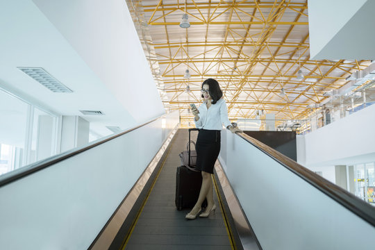 Asian Business Woman With Phone On Escalator