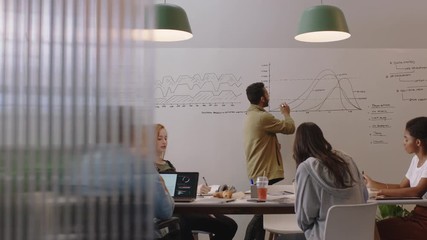 young business people meeting in boardroom brainstorming presentation team leader businessman presenting financial graph data showing colleagues working together in wheelchair friendly office