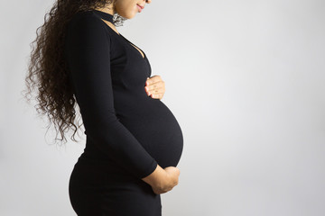 Pregnant woman touching her belly.