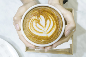 Unknown woman holds latte coffee