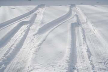 tire tracks in the snow at the parking area