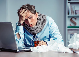 Bad feeling. Sick worker has high temperature. Photo of young man in office suffering virus of flu. Medical concept. - obrazy, fototapety, plakaty