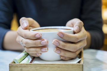 Young woman hands holding hot cup of coffee