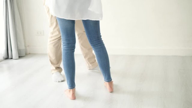 Couple's legs dancing at home together, slow motion.