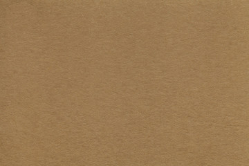 Texture of old brown paper closeup. Structure of a dense cardboard. The background.