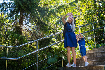 Naklejka premium Cute blonde woman and her daughter in the park