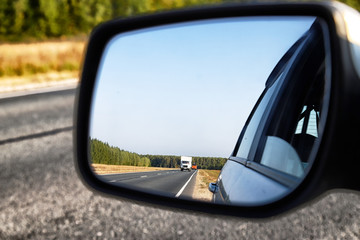 View of the road through the rear view mirror in the car