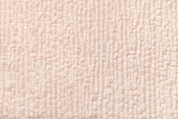 Light beige fluffy background of soft, fleecy cloth. Texture of textile closeup.