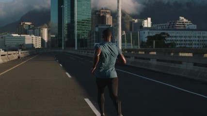 muscular young athlete man running in city road jogging athletic black male exercising endurance workout on urban background slow motion