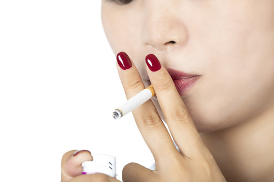 Asian woman lighting a cigarette on white background
