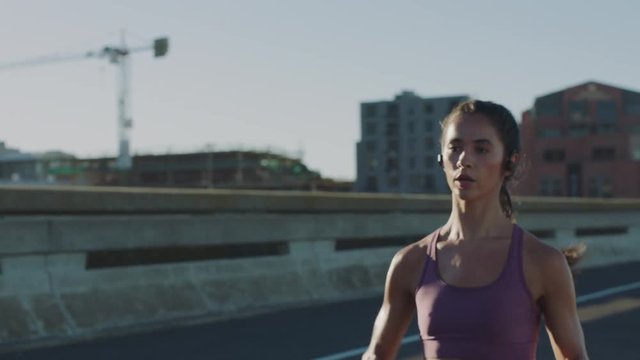 slow motion athlete woman running sprinting training intense cardio endurance workout focused female runner in urban city sunrise