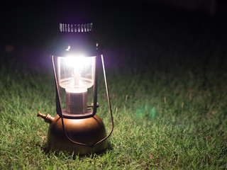Ancient lamps illuminated with oil on the grass at night.