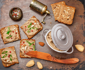 Fresh homemade chicken (duck, goose, rabbit, Turkey) liver pate with almonds, pink pepper and green onions on whole grain bread with seeds.  Traditional healthy snack for gourmets