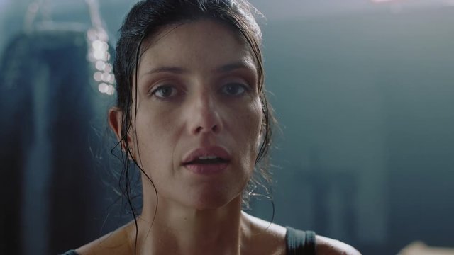 portrait attractive kickboxing woman resting exhausted fighter looking confident at camera breathing tough female kickboxer in fitness gym close up