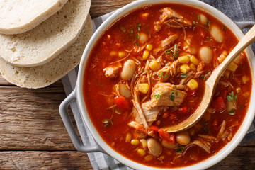 Brunswick Stew - thick, flavorful and hearty one-pot stew with vegetables and meat on a chicken broth and BBQ sauce close-up in a bowl. Horizontal top view