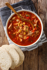 South American food Brunswick Stew pulled meat with vegetables on chicken broth and barbecue sauce close-up in a pot. Vertical top view © FomaA