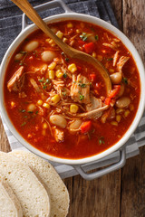 Brunswick Stew - thick, flavorful and hearty one-pot stew with vegetables and meat on a chicken broth and BBQ sauce close-up in a bowl. Vertical top view © FomaA