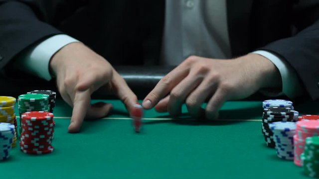 Lucky male player making first bet casually tossing chip, fortune in his hands