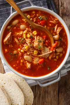 Brunswick Stew - thick, flavorful and hearty one-pot stew with vegetables and meat on a chicken broth and BBQ sauce close-up in a bowl. Vertical top view