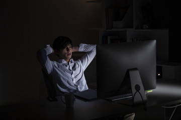 深夜のオフィスでパソコン画面と格闘している会社員