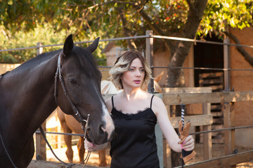 Young beautiful woman next to a horse in a stable