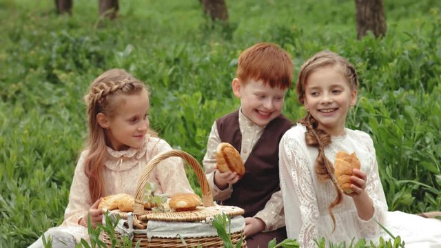 Happy children on a picnic in the blooming garden