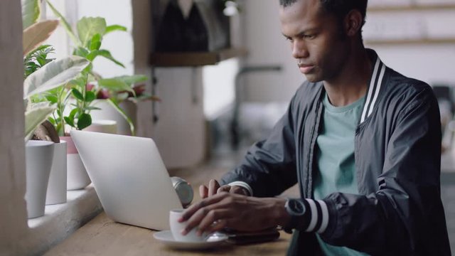 african american businessman using laptop computer in cafe student sharing successful business ideas on social media black entrepreneur drinking coffee working enjoying relaxed lifestyle