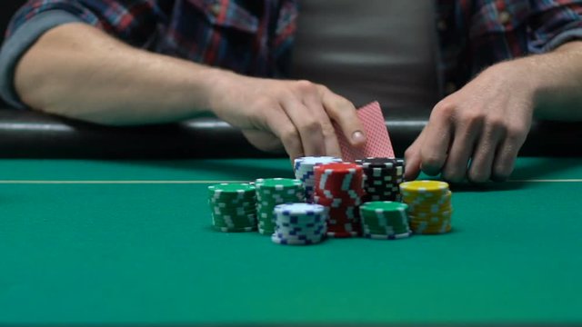 Beginner poker player throwing off his cards losing all money, gambling business