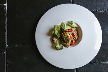 Salad with vegetables, meat, pepper and corn on a large plate