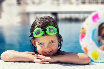 Beautiful little girl swimming at the pool