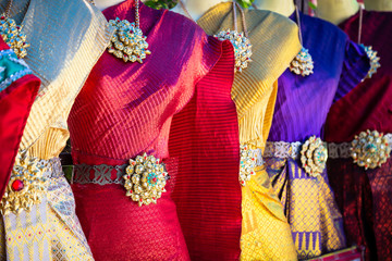 Fototapeta na wymiar Vibrant traditional Thai silk dresses and accessories display