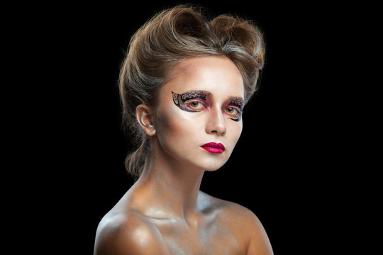 Halloween. Portrait of young beautiful girl with make-up. Isolated on black background.