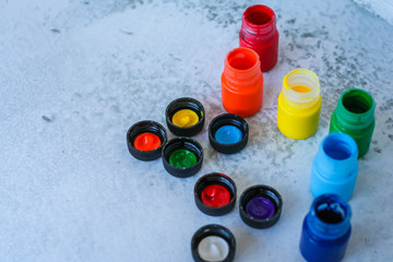 colorful Gouache or acrylic paints in jars on white grunge background, selective focus