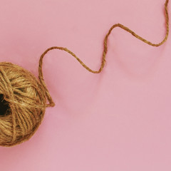 jute rope twine on a pink pastel background, art, minimal, close-up, flat lay