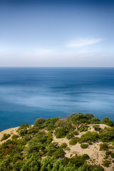 Fototapeta na wymiar Seascape, clear sky. Summer panorama, green vegetation. Calm sea.